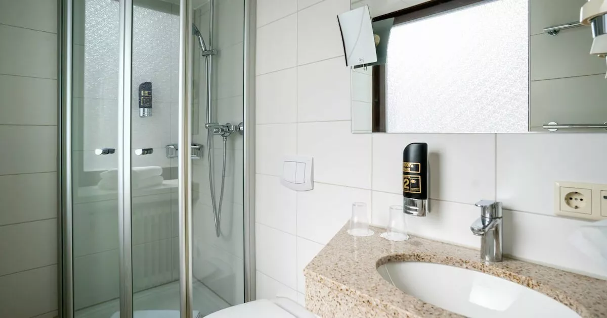 Badezimmer mit Dusche, WC und Waschbecken in einem Doppelzimmer im Europäischen Hof in München