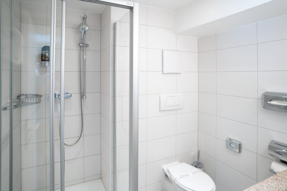 Dusche und Toilette im Badezimmer in einem günstigen Einzelzimmer in München
