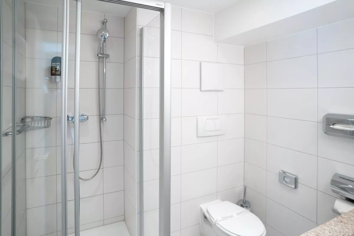 Dusche und Toilette im Badezimmer in einem günstigen Einzelzimmer in München