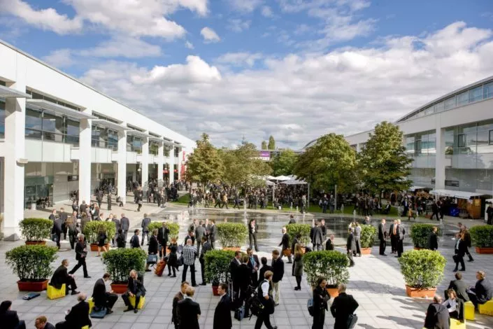 Viele Menschen in Business Outfits im Atrium der Messe als einfach erreichbares Ziel von unserem Hotel für Messen in München