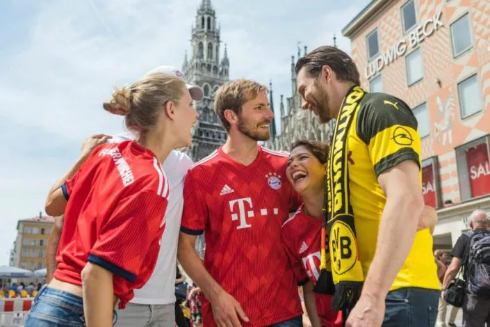 Fußballfans in Bayern und Dortmund Trikots auf dem Marienplatz in München