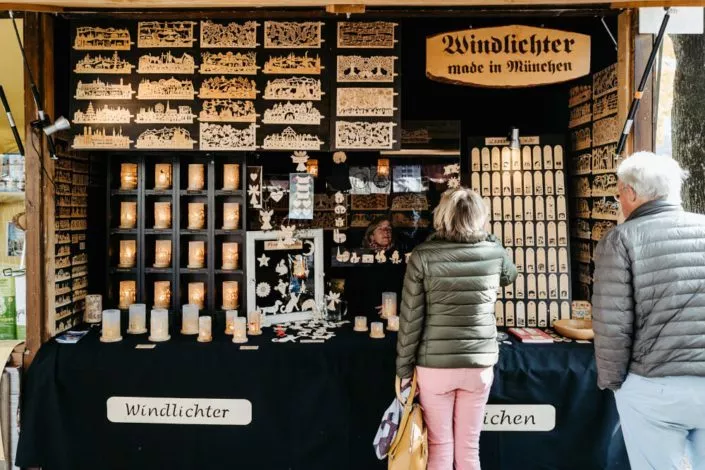 Zwei Personen an einem Verkaufsstand mit Windlichtern aus Holz