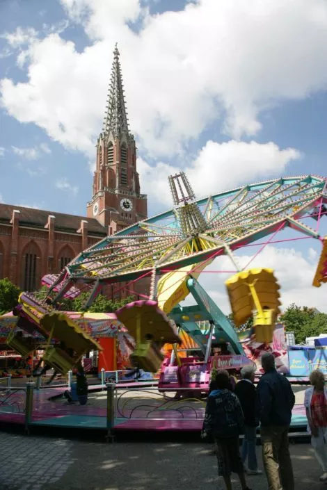 Karussell vor einer roten Kirche auf dem Mariahilfplatz in München