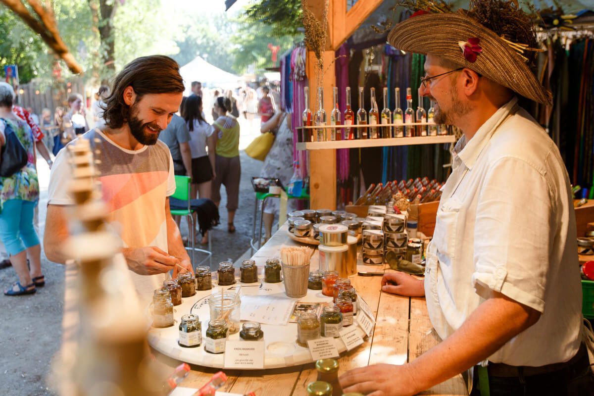 Mann bei Besuch an Tollwood Stand, © München Tourismus, Christian Kasper Mann bi Besuch an Tollwood Stand